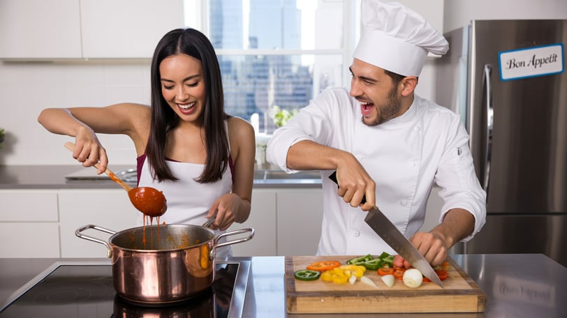 a man and woman in chef hats preparing food
