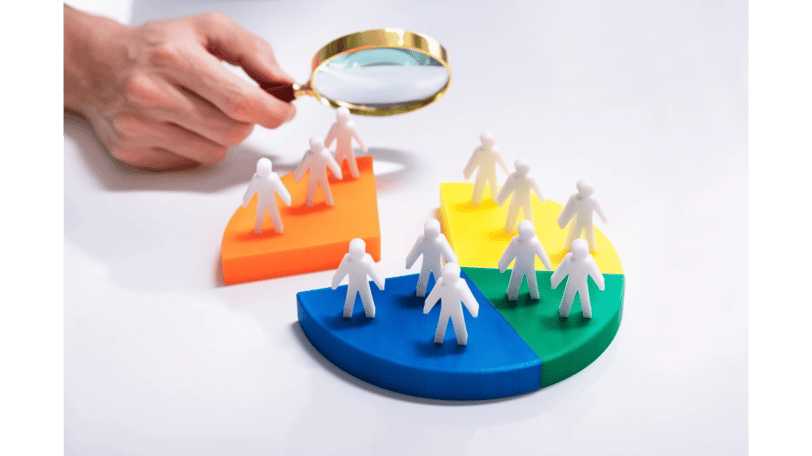 Magnifying glass analyzing audience on pie chart | Market research and customer segmentation