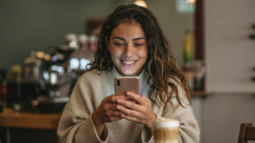 a woman in a sweater holding a cell phone