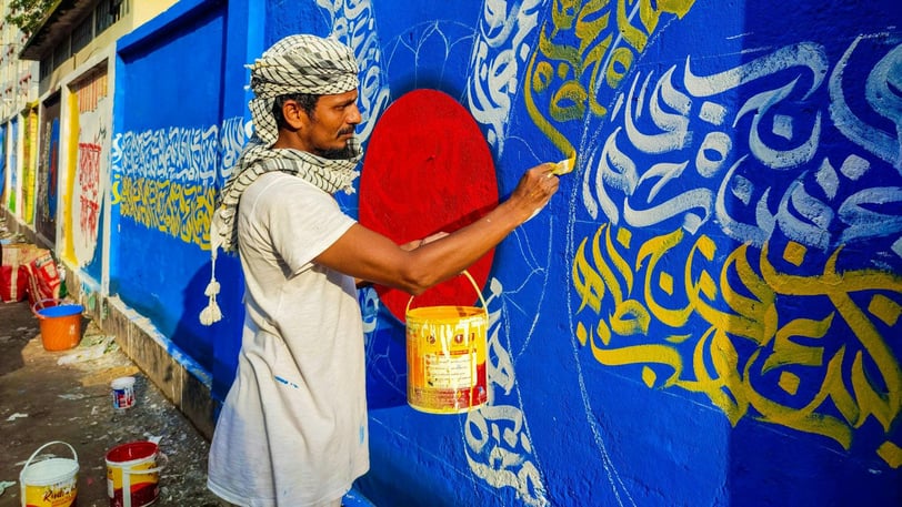 Imagem de um homem grafitando um muro