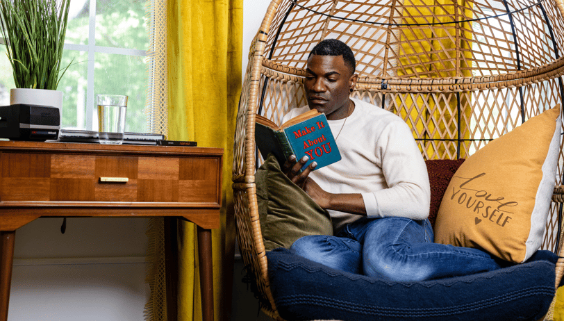 a man sitting in a chair reading a book