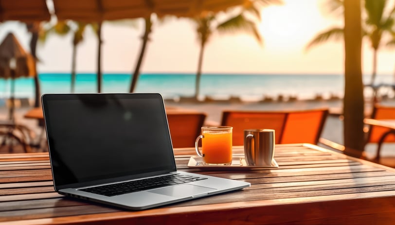 a laptop computer sitting on a table facing a beach