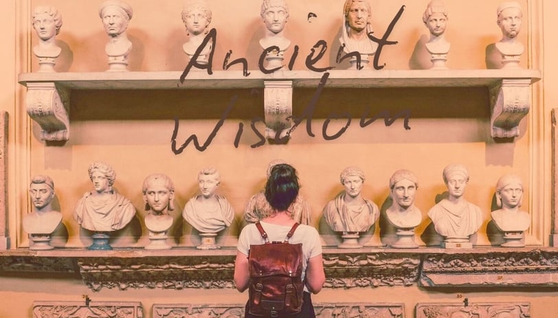 a woman standing in front of a display of ancient sculpture
