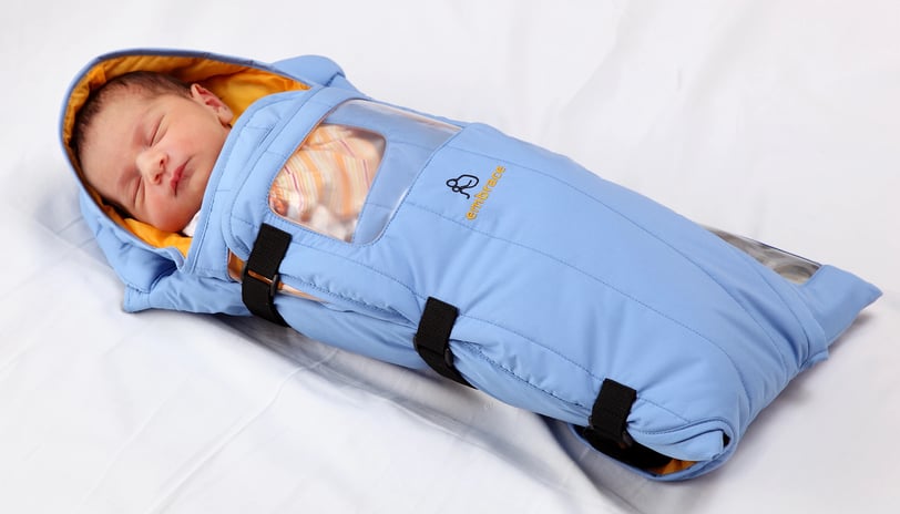 a baby in a portable infant incubator by Embrace Global