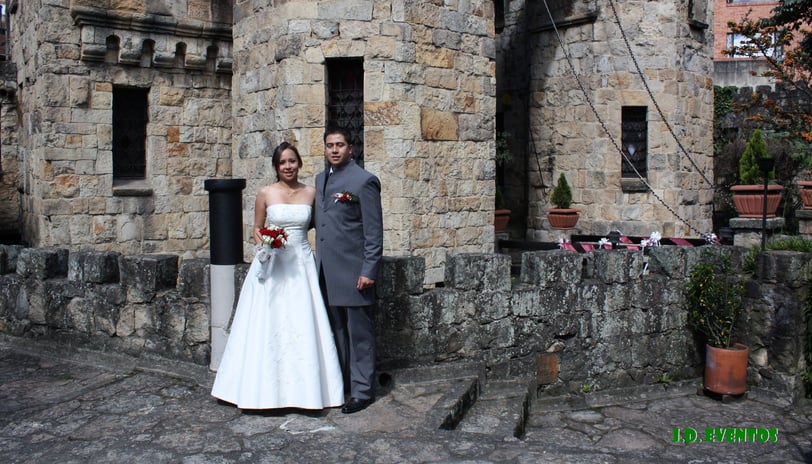 a bride and groom standing in front of a castle