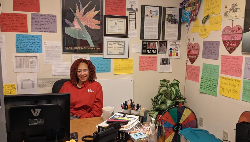 Felecia sitting at her office desk surrounded by sweet notes posted on the walls