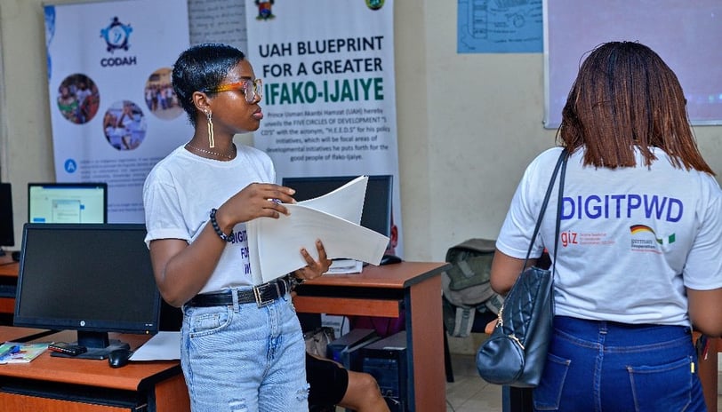 2 girls standing on opposite sides, with one having an inscription on the back of her shirt "DIGITPWD"