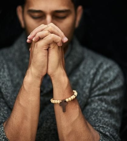 A young man praying with his eyes closed