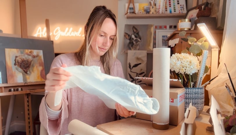 Alex working in her studio wrapping print order for shipping