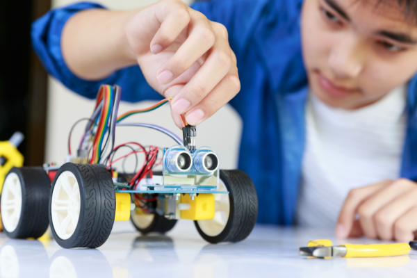 a boy is playing with a robot - controlled toy car
