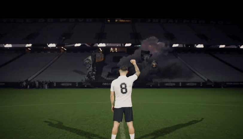 a man holding a soccer ball in front of a stadium, Rodrigo Garro