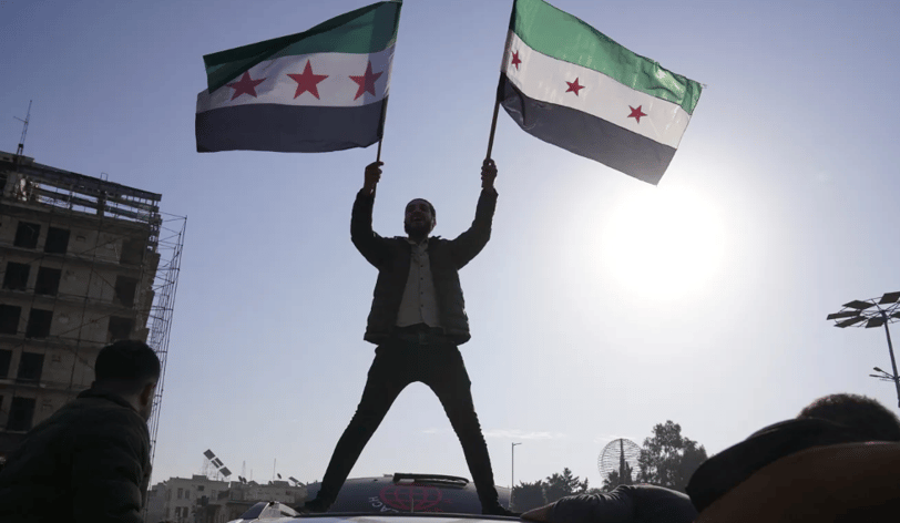Man holding flags of Syrian Opposition Group
