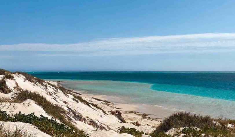 Beautiful white sand beach at Coral Bay with crystal-clear turquoise water, in Western Australia.