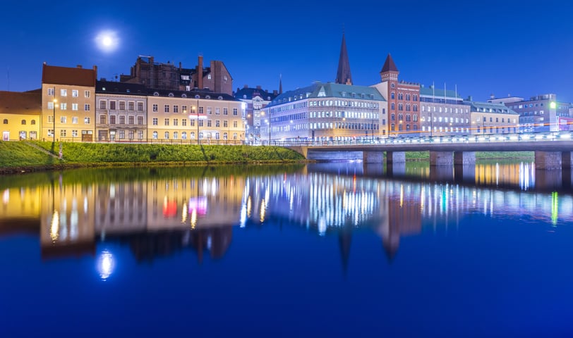 Night city mirrored in the water. Evening panorama of the old European City of Malmo, Sweden