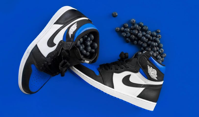 a pair of black and white sneakers with mini black balls, Nike Air Jordan 1