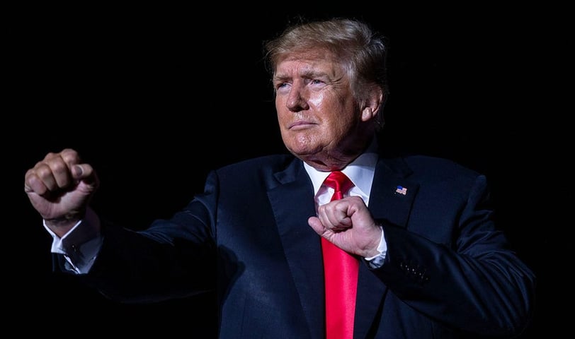 a man in a suit and tie is pointing at something