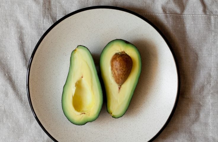 Abacate cortado em um prato para lembrar que as frutas não engordam se consumidas com moderação