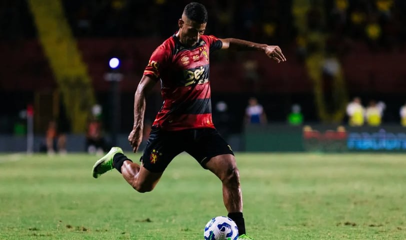 a man in a red shirt is playing soccer