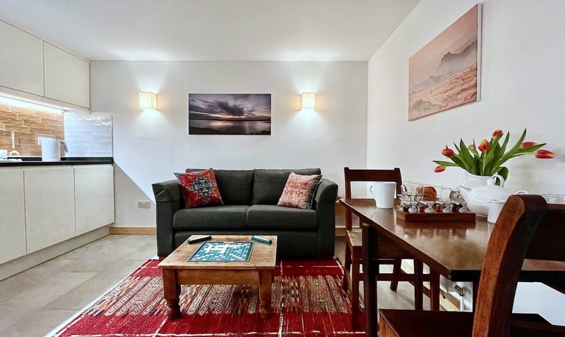 a lounge area with kitchen and dining space