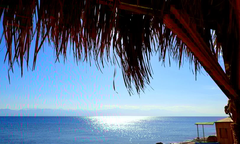 Sent l'energia del sol jugant amb el mar davant de la platja