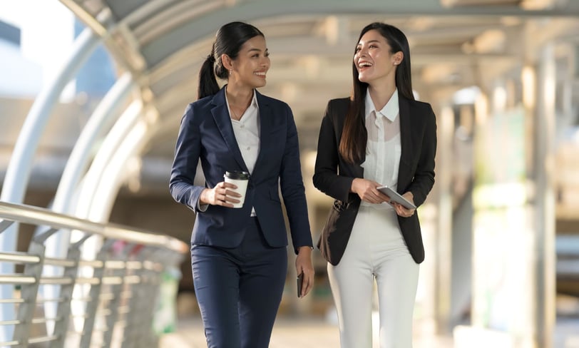 2 women walking in a building