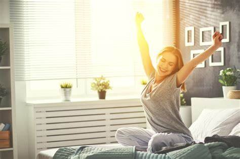 femme assise dans son lit au réveil