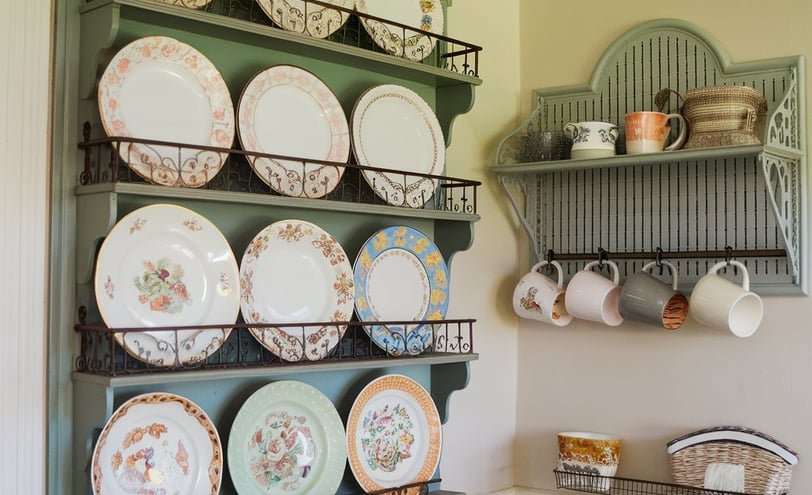 a kitchen with a peg rail shelf with plates and bowls