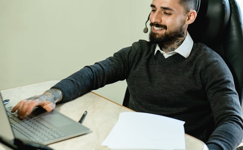 virtual assistent bezig op zijn laptop met tattoo