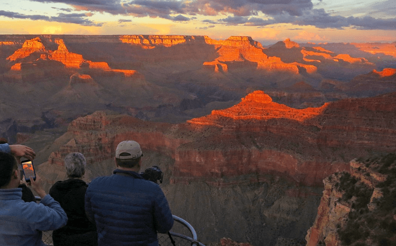 Tourist at Grand Canyon North Rim at Sunset