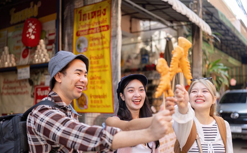 Friends celebrating their travel adventures, joyfully sharing crispy street food