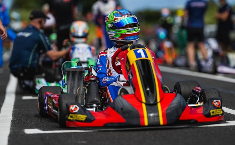 Pilote de kart numéro 1 attendant le départ d'une course sur la ligne de départ.