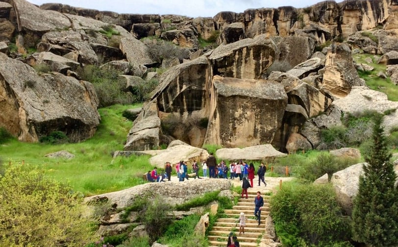 a group of people walking up stairs in a rocky area