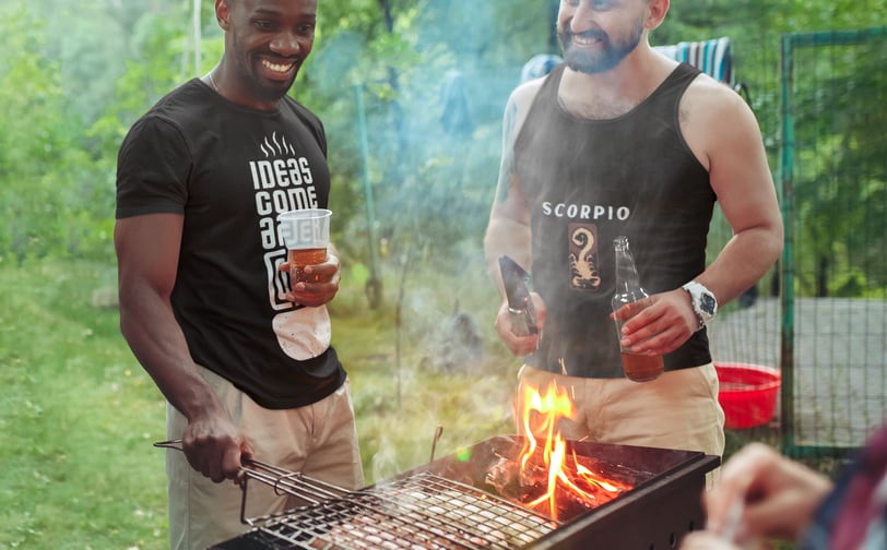 a man and a woman are standing around a grill