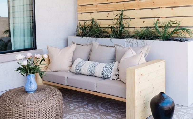 a couch with pillows and pillows on a patio