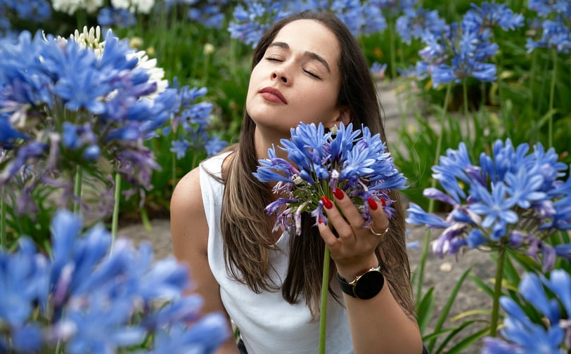 a woman is holding a flower in front of a flower