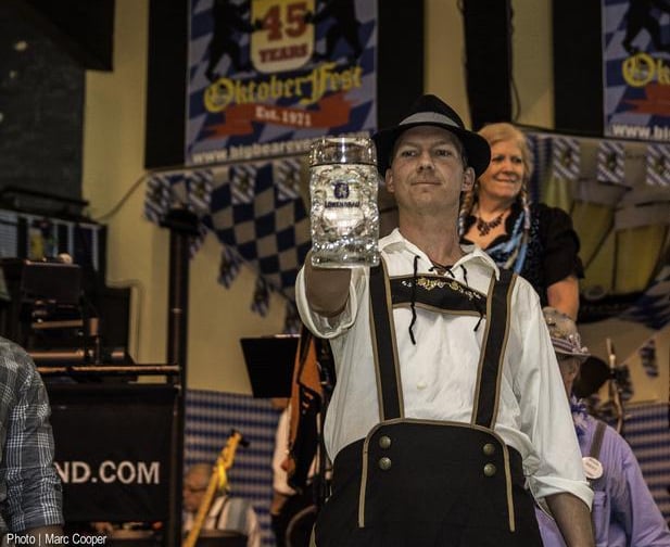 a man in a bavarian beer outfit holding a beer glass