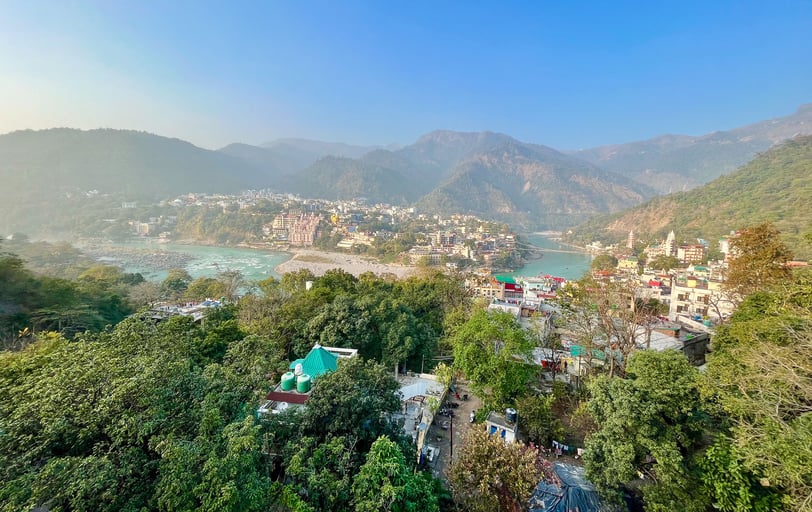 Scenic rooftop view overlooking the Himalayas and the Ganges River in Rishikesh, India, during a yoga retreat.