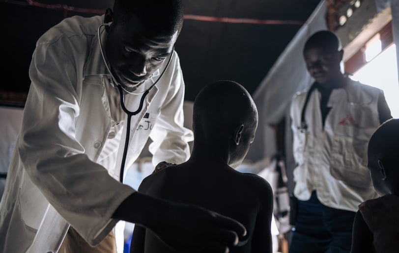 a doctor examining a child's chest with a stethoscope