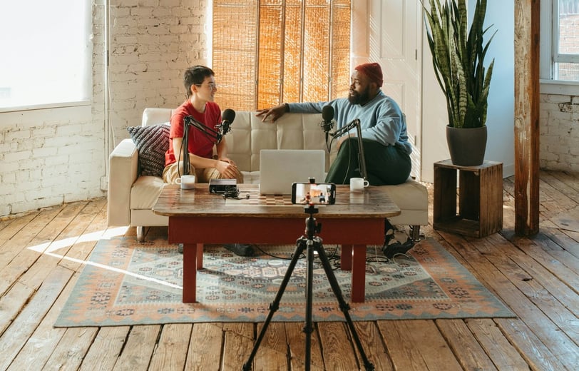 Video podcasters sitting on a couch in a loft