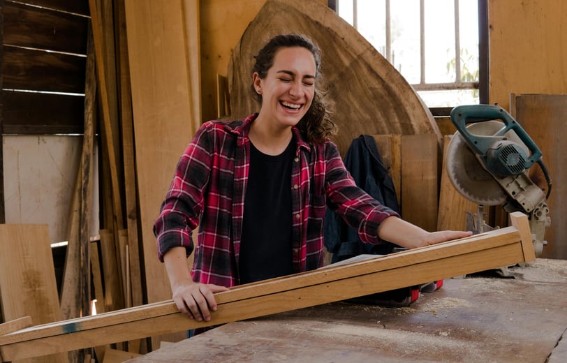 a woman in a plaid shirt in a woodwork shop