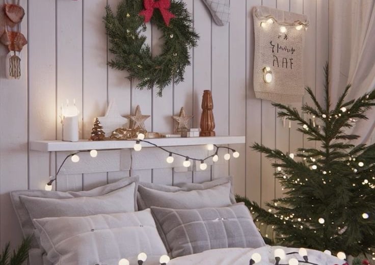 a bedroom with christmas lights and a christmas tree