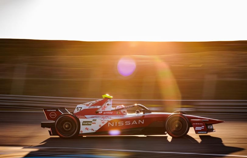 a man driving a Formula E race car on a track