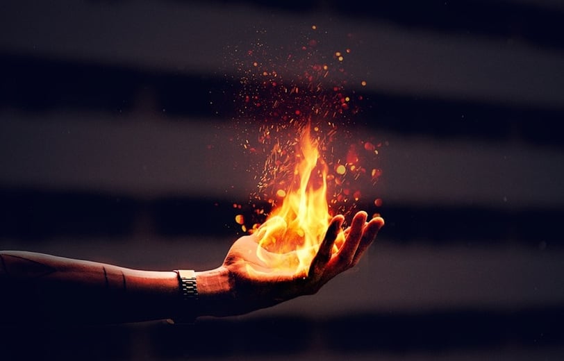 Young person holding fire in their hand.