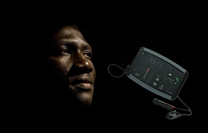 Man in the dark, with a CES machine next to him.