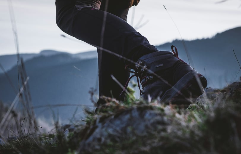 a person standing on a hill with a backpack