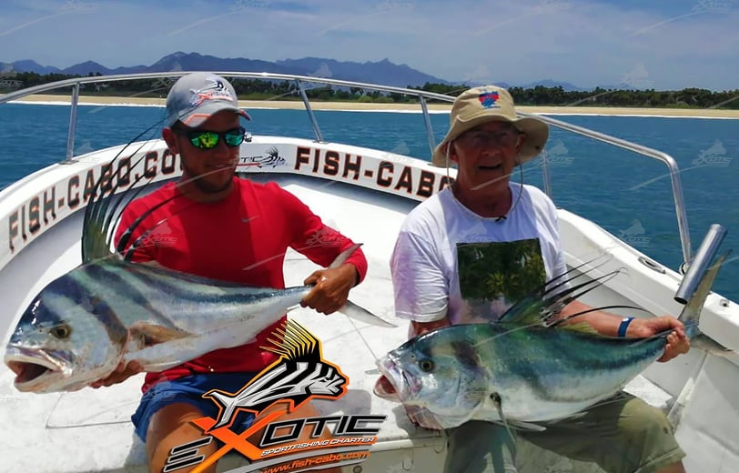 two men holding fish on a boat in the ocean