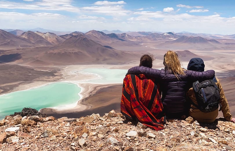 Photo de trois amis de dos face à la Laguna Verde depuis le sommet du volcan Licancabur.