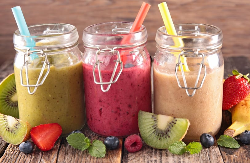 three jars of fruit smoothies with fruit and strawberries