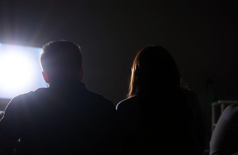 a couple watching television in the dark