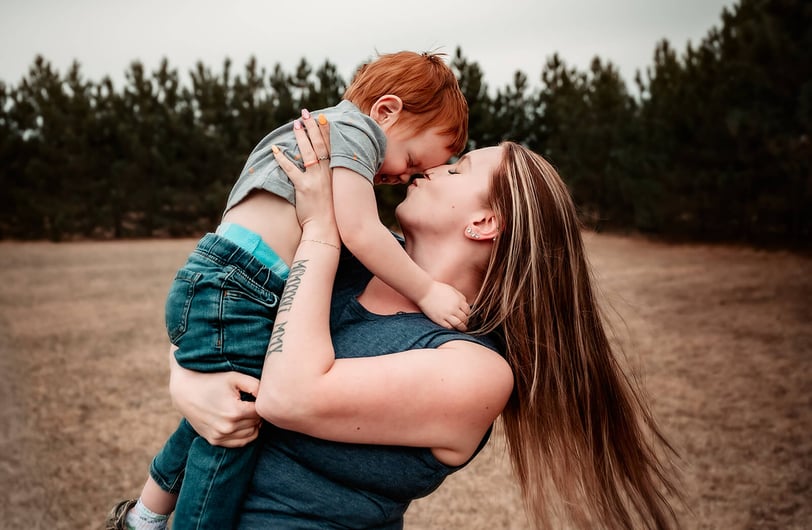 Duluth Mama spinning toddler around and kissing him on the nose